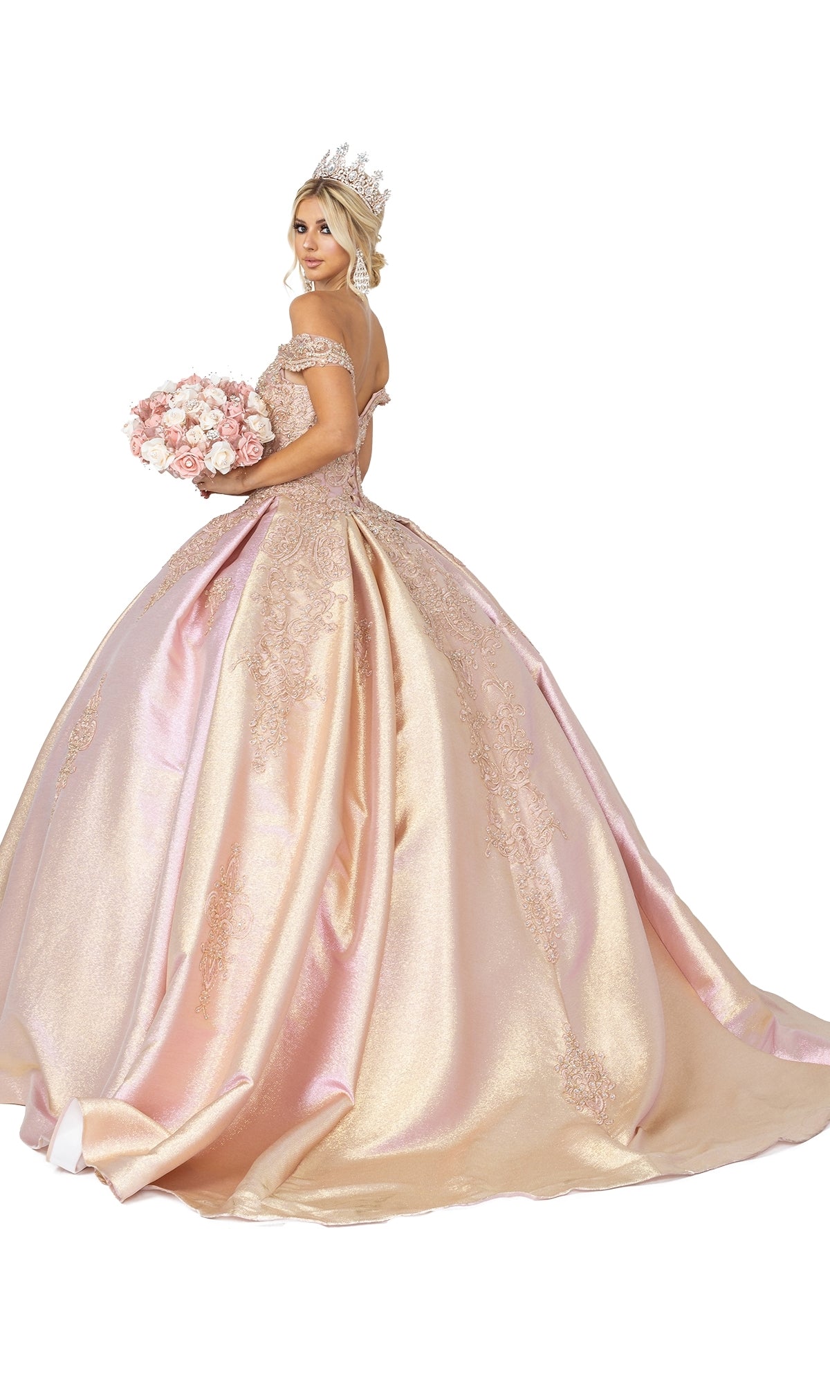 A woman in the Quinceanera Dress 1585 by Dancing Queen, featuring a gold ball gown with a sweetheart neckline, crown, and pink rose bouquet, poses against a white background.